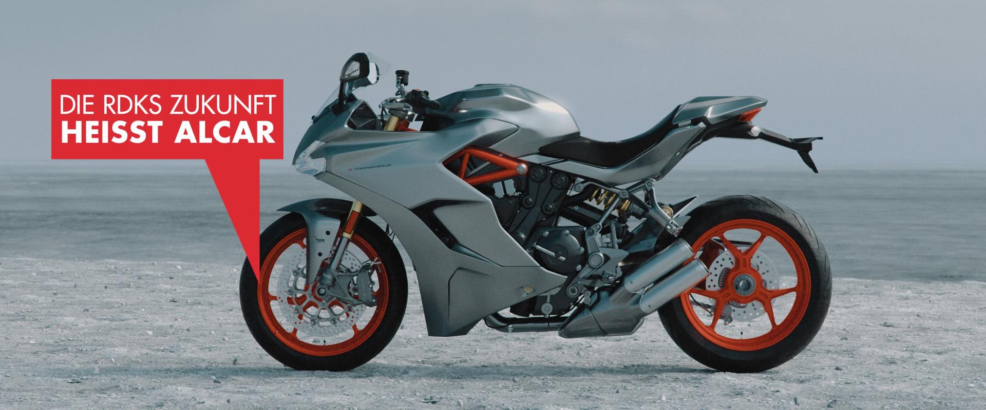 Siberfarbenes Motorrad mit orangfarbenen Felgen von der Seite