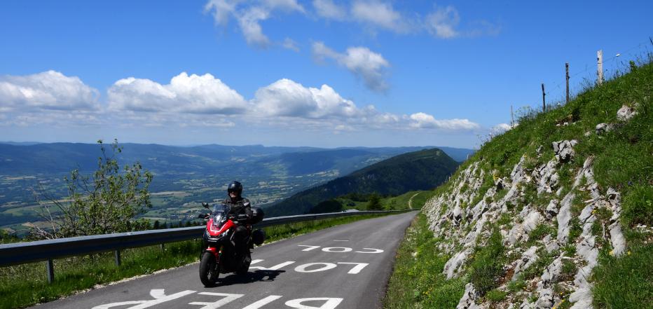 Motorradfahrer unterwegs auf Slowenische Grenzkammstraße, mit schönem Panorama