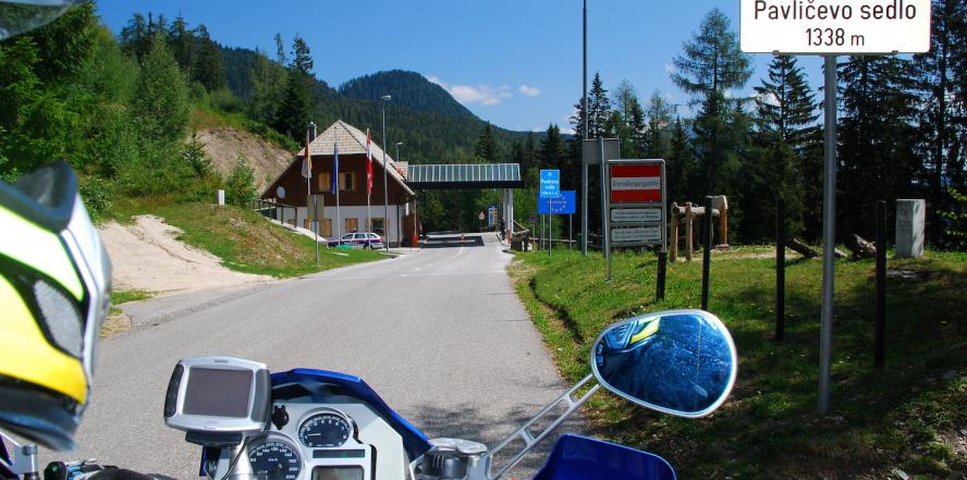 Motorradfahrer auf der Passhöhe des Paulitschsattel, mit Blick auf das Passschild