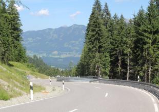 Kurvige Straße im Wald mit Aussicht auf dem Riedbergpass