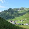 Ausblick des Faschinajochs, auf Dorf, Wiesen und Berge 