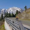 Motorrad auf der Rossfeld Panoramastraße, mit Bäumen und Bergen im Hintergrund