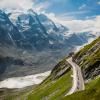 Motorradfahrer unterwegs auf der Großglockner Hochalpenstraße, mit Blick aufs Tal und die umliegenden Berge