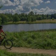 Ebikerin fährt an einem See in Mecklenburg-Vorpommern entlang